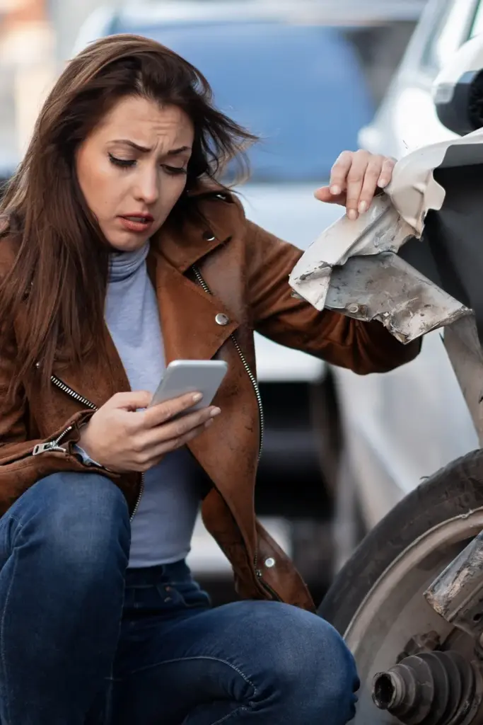 Woman Making Call Next to Wrecked Car