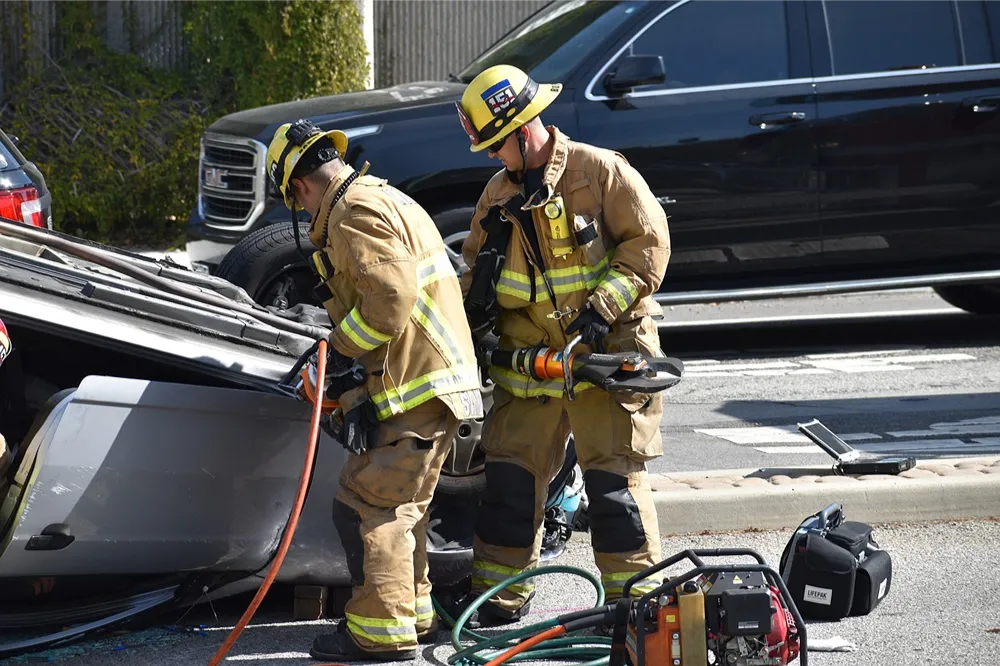 Two firefighters attend a car accident